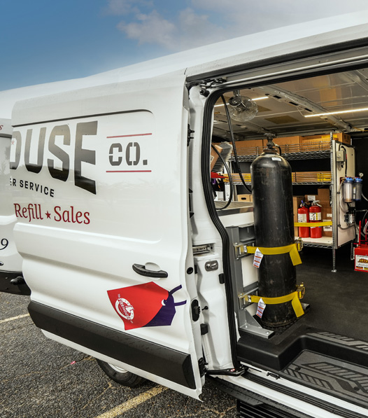 a view of a fire extinguisher service van with an open door showing fire extinguisher inspection equipment
