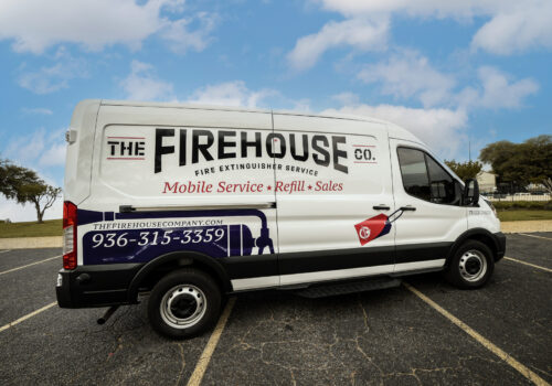 The exterior of The Firehouse Co. mobile service van sitting in an empty parking lot